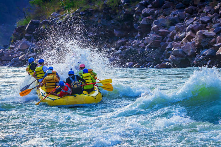 Mit dem Rafting-Boot unterwegs auf dem reißerischen Wasser eines Flusses 