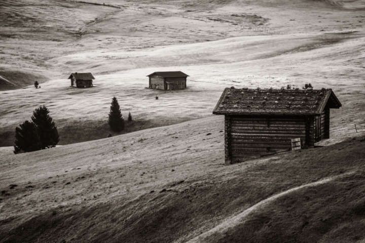 Altes schwarzweiß Bild einer Almwiese mit mehreren Hütten