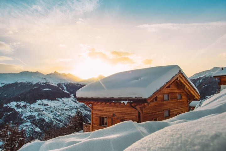 Luxus Ferienhaus in den schneebedeckten Bergen mit Blick auf den Sonnenuntergang